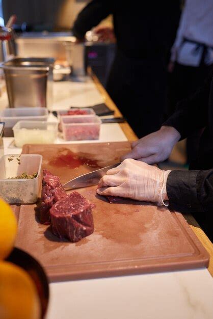 Chef Carnicero Cortando Carne De Cerdo Con Cuchillo En La Cocina