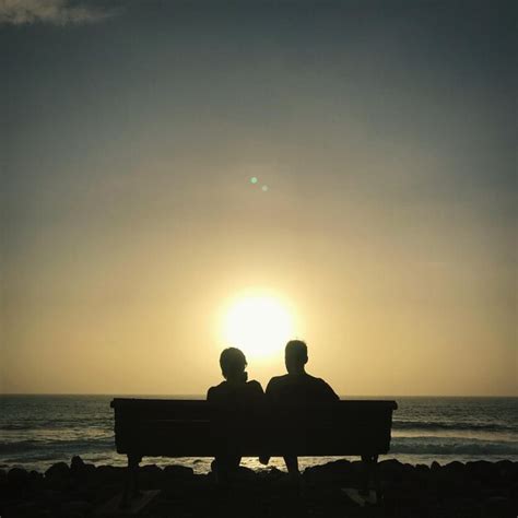 Premium Photo | Silhouette people sitting on bench at beach during sunset