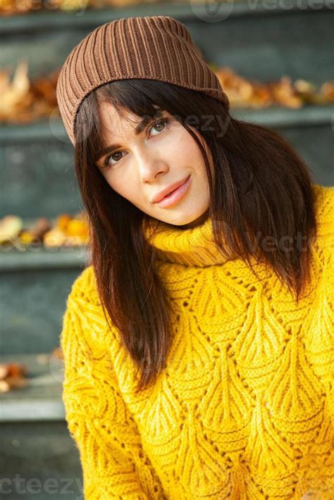 Beautiful European Brunette Dressed In A Yellow Woolen Sweater And Hat Outside The Beautiful