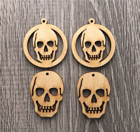 Three Wooden Skull Ornaments Hanging On A Wood Background With The