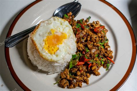 Stir Fried Thai Basil With Minced Pork And A Fried Egg On White Plate 2023