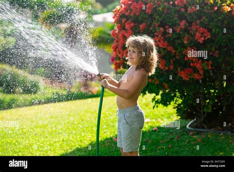 El niño está regando la planta fuera de la casa concepto de actividad