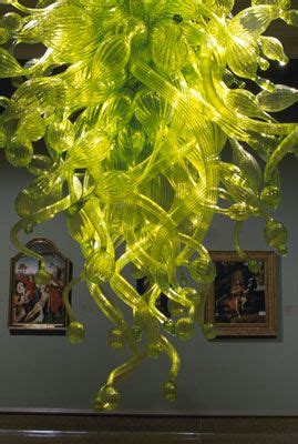 A Green Glass Sculpture Hanging From The Ceiling In A Room With