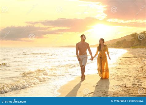 Happy Young Couple Walkingon Beach At Sunset Stock Image Image Of