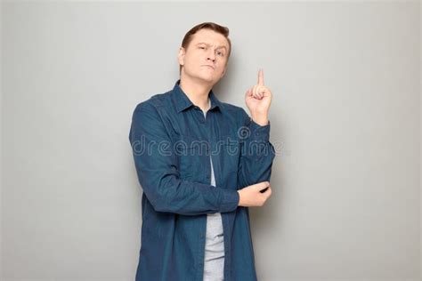 Portrait Of Serious Mature Man Raising Index Finger And Making Notice