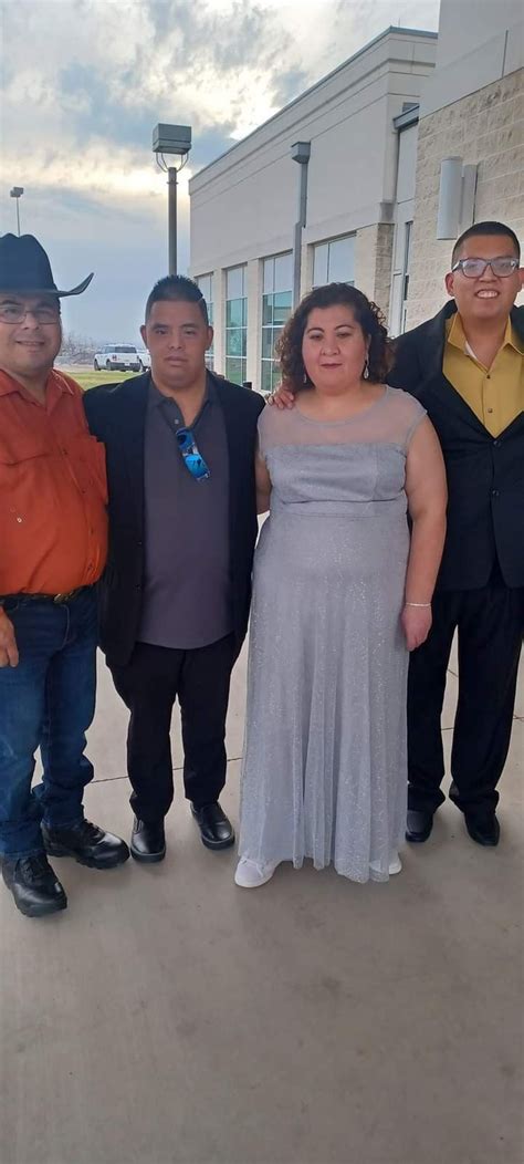 Three Men And A Woman Standing In Front Of A Building