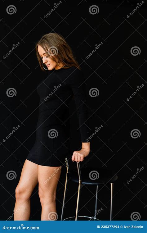 Seductive Pose Of Dark Haired Woman Wearing A Black Bikini Stock Photo