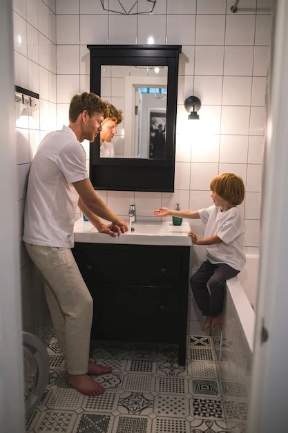 Papa et son fils dans la salle de bain font leurs procédures du matin