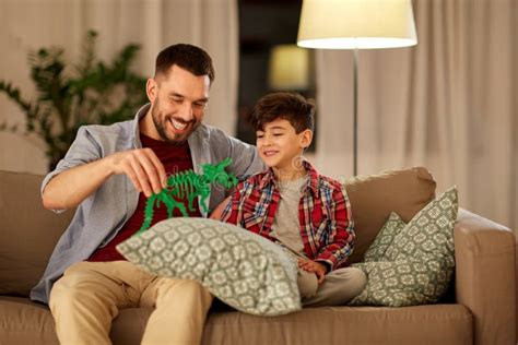 Fader Och Son Som Hemma Spelar Med Leksakdinosaurien Arkivfoto Bild