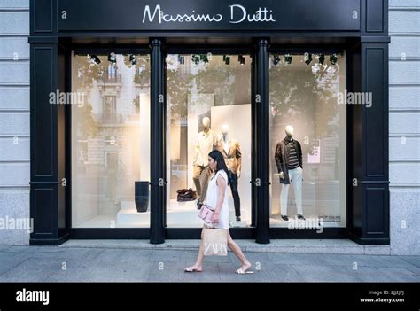 A Pedestrian Walks Past The Spanish Clothing Manufacturing And Brand Massimo Dutti Store In