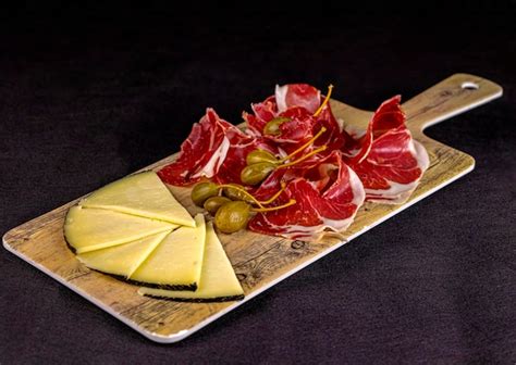 Premium Photo Iberian Ham And Manchego Cheese Board With Capers