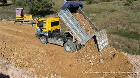 Komatsu Bulldozer Pushing Dirt And Mini Dump Trucks Unloading Dirt