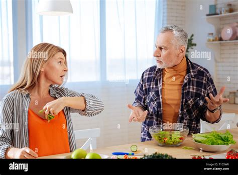Blonde Emotional Wife Throwing Piece Of Lettuce Into Her Husband Stock Photo Alamy