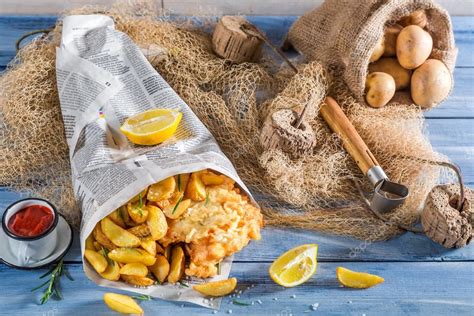 Tasty fish cod with chips in newspaper with lemon — Stock Photo ...