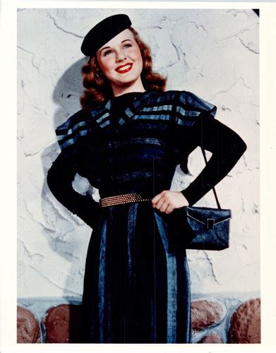 Deanna Durbin Smiles As She Poses With Purse And Hat Against Wall 8x10