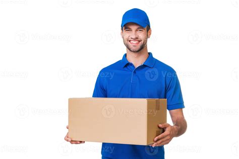 Cheerful delivery man. Happy young courier holding a cardboard box and