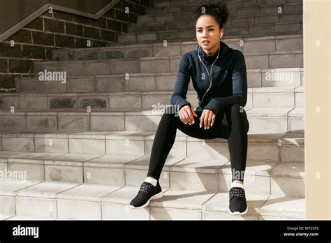 Athlete Woman Resting During Her Workout Sitting On Stairs Stock Photo