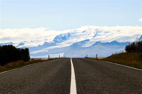 Straight Asphalt Road With A Snowy Mountain In Viki South Iceland