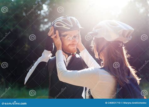 Happy Couple Wearing Protective Bicycle Helmets In Park Man And Woman