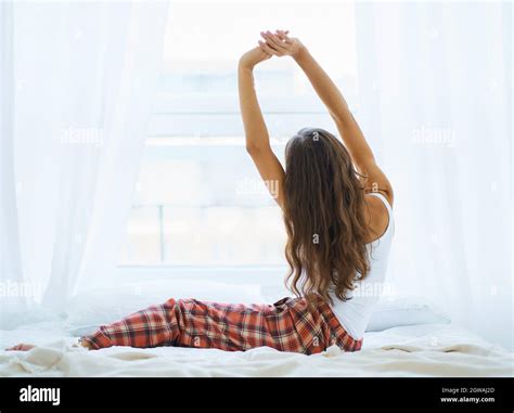 Back View Of Woman Stretching In Bed After Wake Up Entering New Day