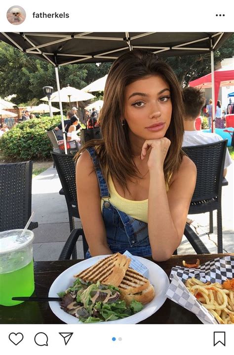 A Woman Sitting In Front Of A Plate Of Food