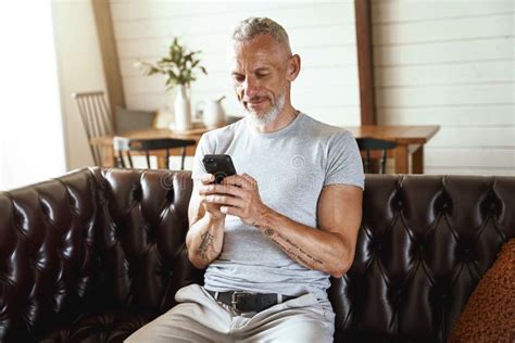 Texting Message Middle Aged Caucasian Man In Casual Clothes Using His Smartphone While Sitting