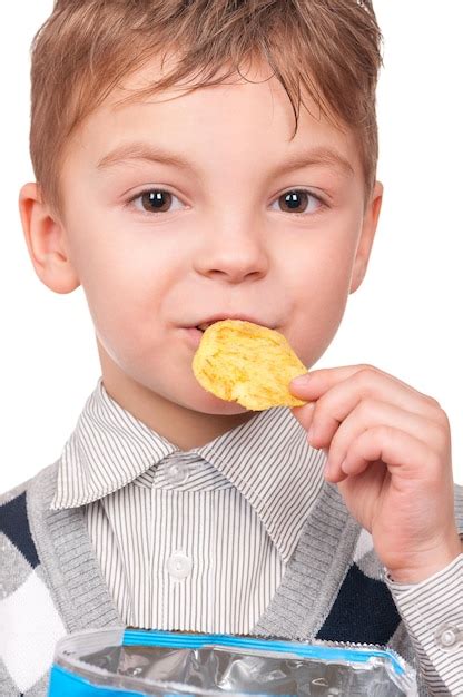 Retrato de un niño alegre con un paquete de papas fritas en primer