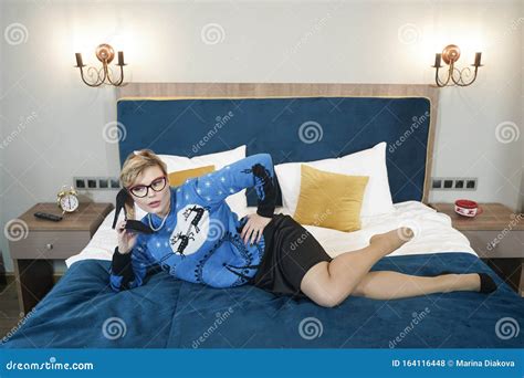 Elegant Curvy Blonde Woman In Glasses Lying On The Bed In Xmas Sweater