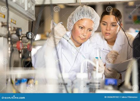 Confident Women Technicians Working In Research Laboratory Stock Photo