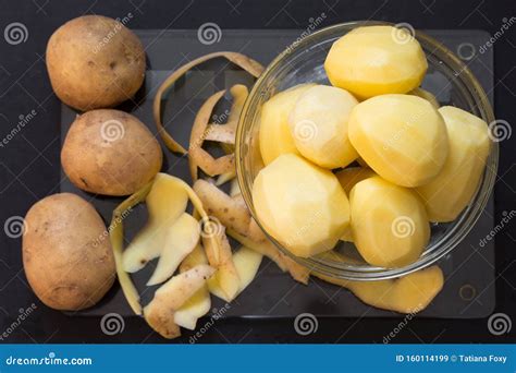 Top View Of Raw Unpeeled Potato With Peels And Peeled Potato In Glass