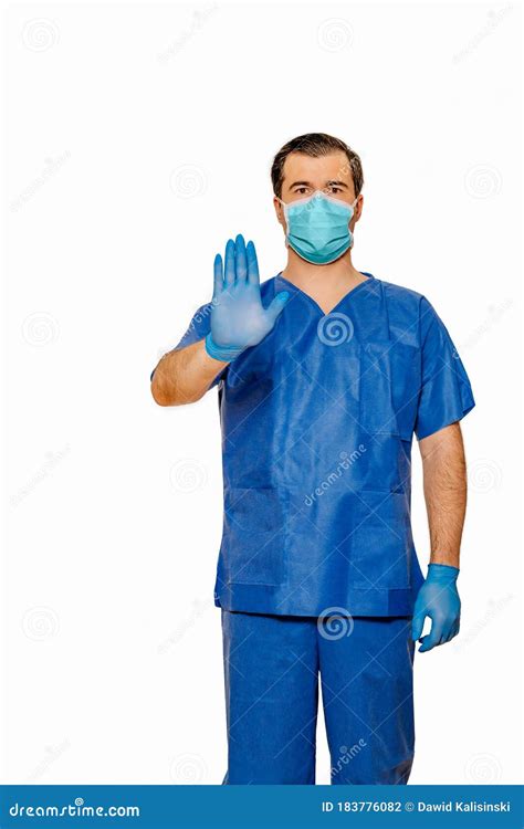 Male Doctor In Scrubs With Protective Face Mask And Gloves Showing Stop