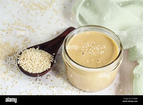 Top View Of Mason Jar Filled With Tahini Wooden Spoon Overflowing With