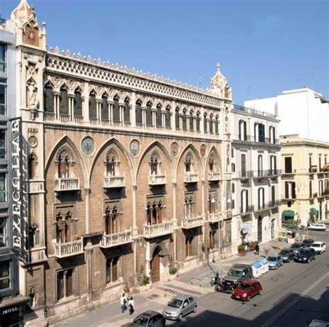 An Old Building With Many Windows And Balconies On The Top Floor Is Shown