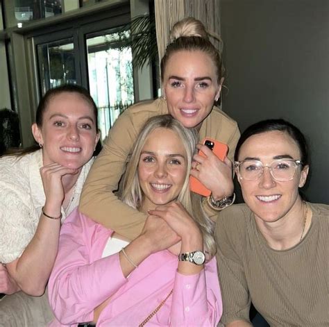 three women and one man posing for the camera