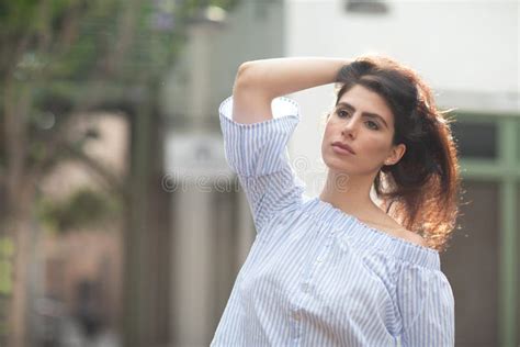 Beautiful Flirty Brunette Playing With Her Hair On A Alley Of A City Shallow Focus Stock Photo