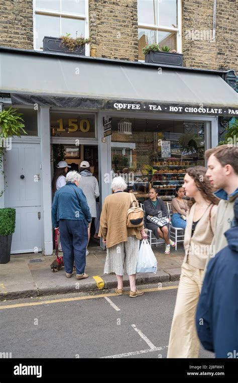 People out and about shopping on a Sunday market day take a break at ...