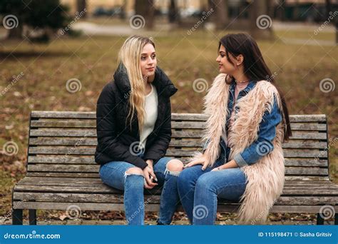 Two Girls Sitting On The Bench Outdoors Stock Image Image Of Autumn