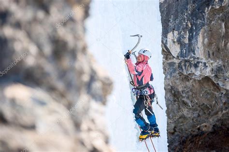 Girl mountaineer climbing a frozen waterfall and smiling Stock Photo by ©Joe-L 90460886