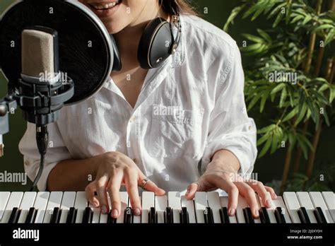 Smiley Female Musician Playing Piano Keyboard Indoors Singing Into