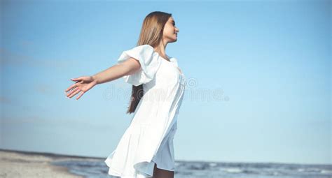 Happy, Beautiful Woman on the Ocean Beach Standing in a White Summer