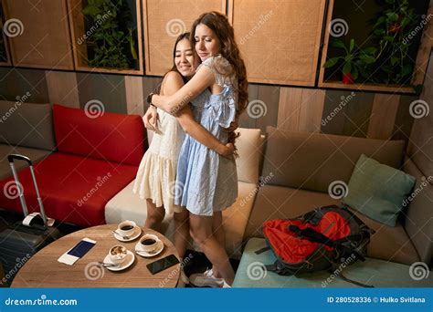 Lovely Hugs Of Pretty Girlfriends In Hotel Lobby Before Departure Stock