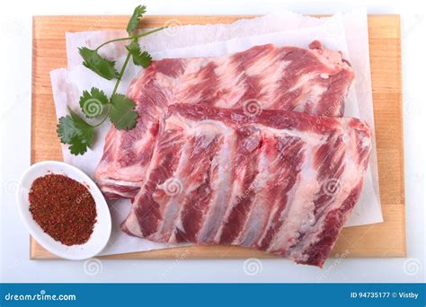 Raw Pork Ribs With Herbs And Spices On Wooden Board Ready For Cooking