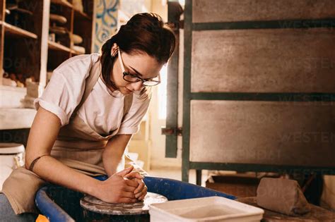 Woman Moulding Clay On Pottery Wheel Craftswoman Making Pot In