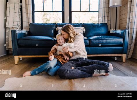 Caucasian Mother Snuggles With Preschool Age Boy In Cabin Stock Photo