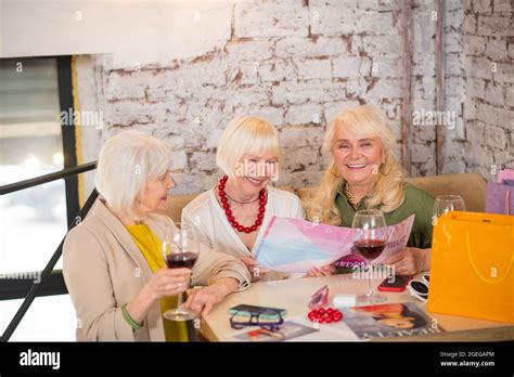 Three Mature Women Sitting At The Table And Looking Excited Stock Photo Alamy