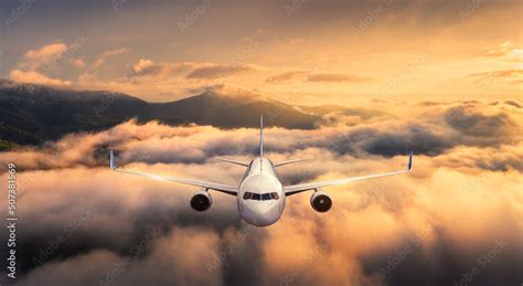 Airplane Is Flying Above The Clouds At Sunset In Summer Landscape With Passenger Airplane