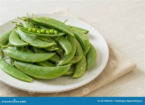 Guisantes Dulces Y Verdes Frescos En El Plato Imagen De Archivo