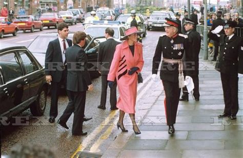 The Queen And Prince Are Walking Down The Street With Other People In