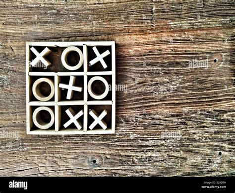 Wooden Tic Tac Toe Or Noughts And Crosses Game On A Grainy Tabletop