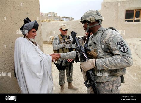 Us Army Soldier Shakes Hands With An Elder In A Village In